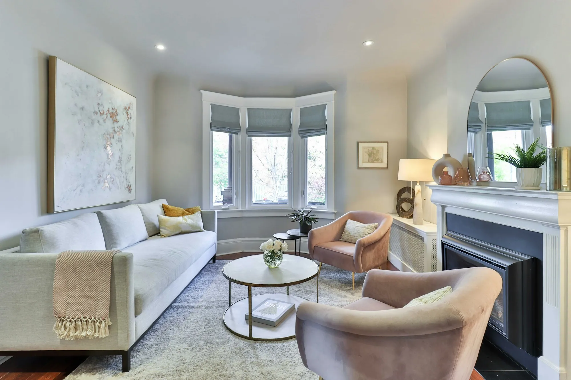 Living room with a fireplace, bay window and soft seating