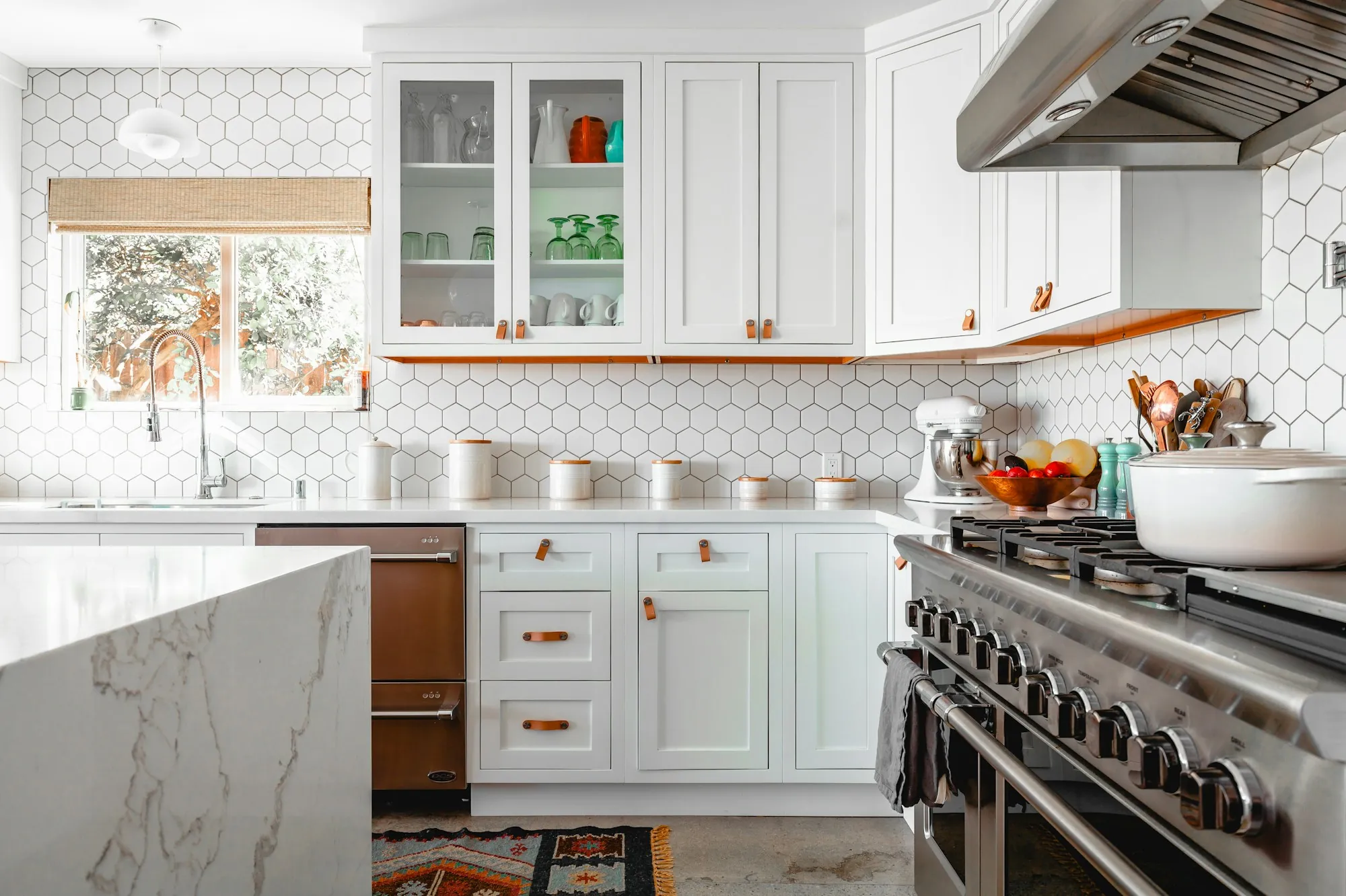 Kitchen with white cabinets, hexagon tile and a professional range